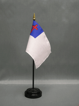 an image of a white miniature flag with a blue square and red cross in the top left corner set in a circular black flag stand